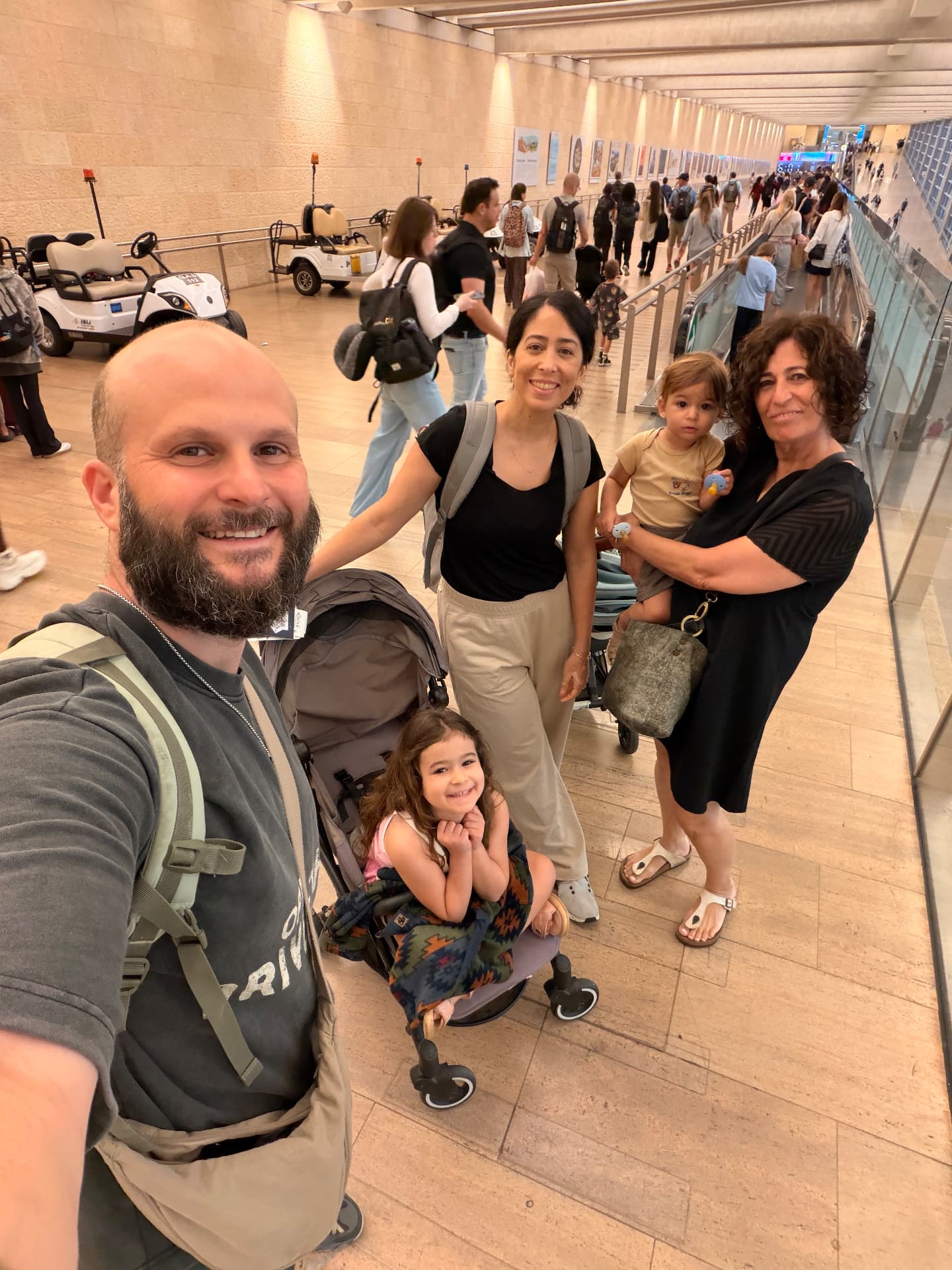 המשפחה עם העגלה במסדרון היציאה בנמל התעופה בן גוריון